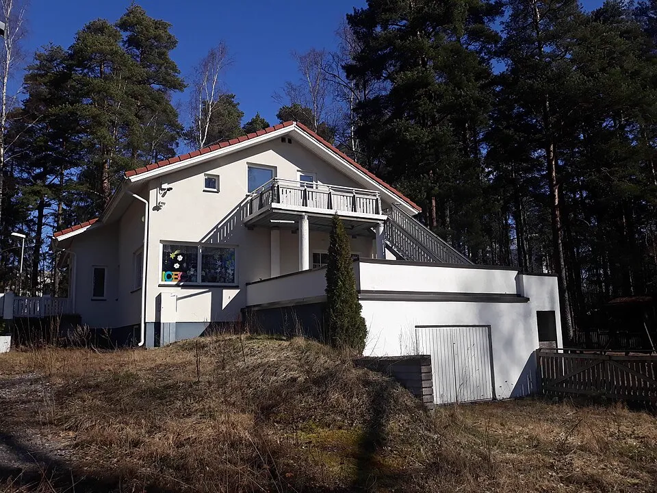 Valkoinen omakotitalo puiden ympäröimänä Havukujalla Helsingissä